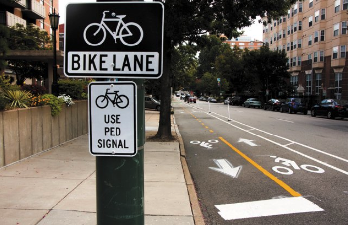 Street sign saying "Bikes Use Pedestrian Signal"