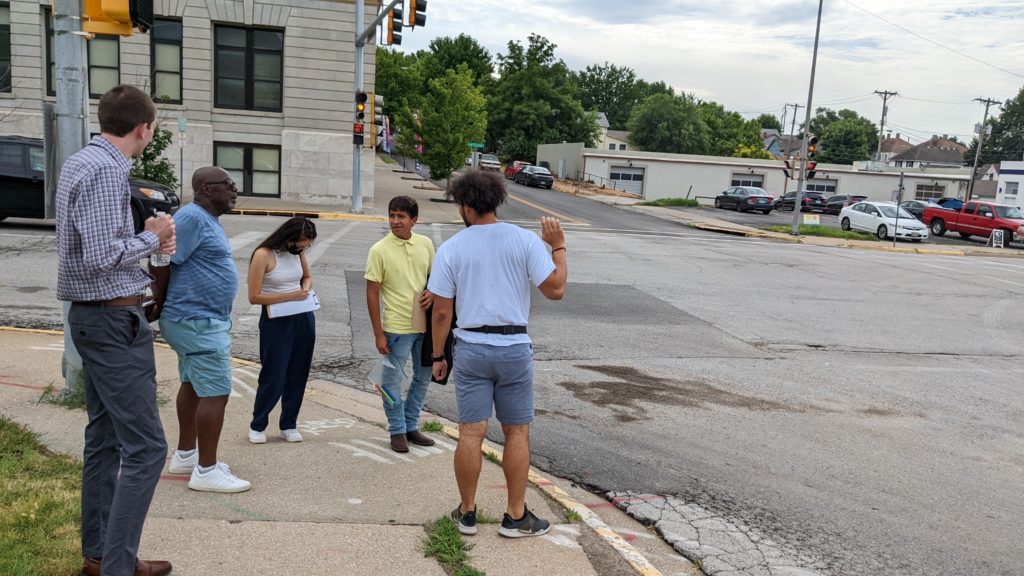 Walk auditors stand at an intersection with T.J. Roberts of Kinship Cafe