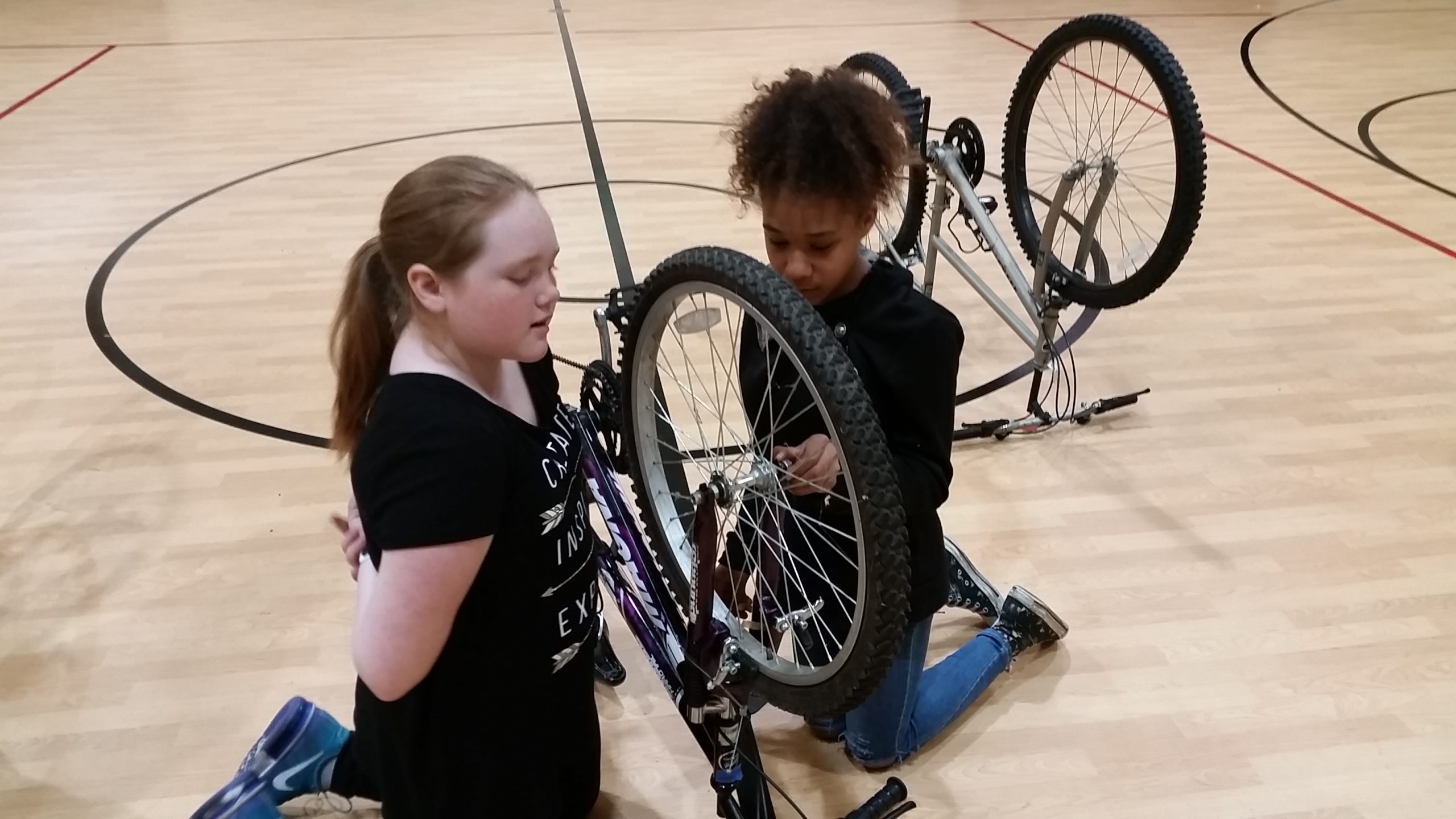Two students practice fixing a flat at a Maintain Your Ride + Earn-a-Bike class