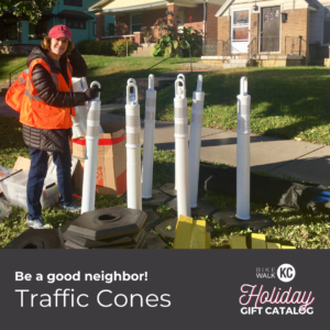 Person prepares to place large white cones in a traffic-calming installation. BikeWalkKC's Holiday Gift Catalog