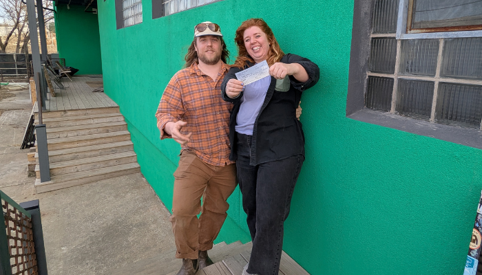 Big Muddy owners Nathan and Gina present BikeWalkKC with a check from the proceeds of consignment sales