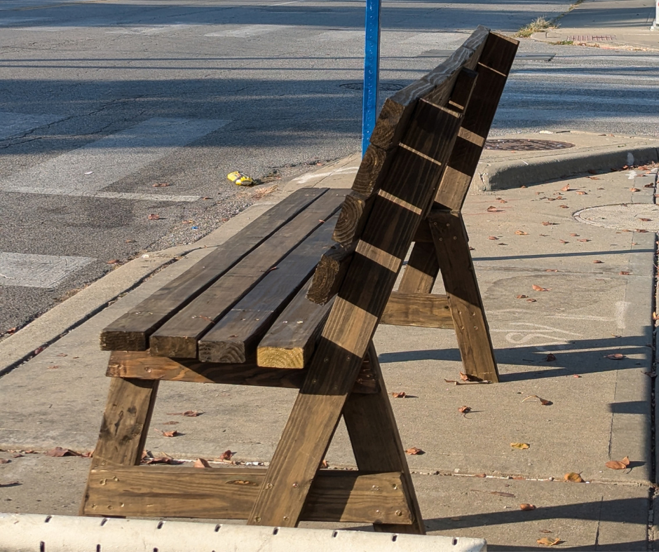 A homemade bench at a bus stop offers transit riders a place to rest while they wait for their bus.